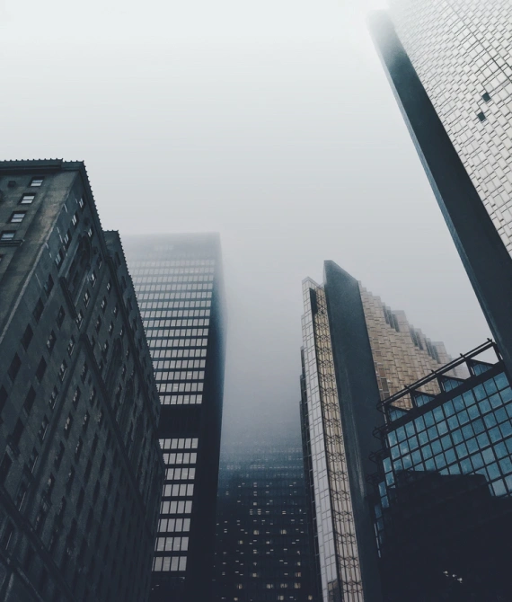 Perspective of many-storeyed buildings rising into the misty sky